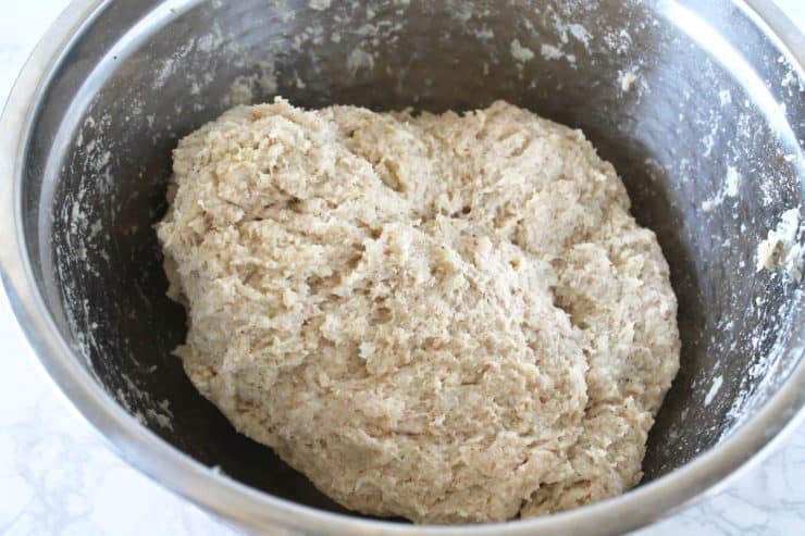 Close up of kneaded bread dough in a metal mixing bowl