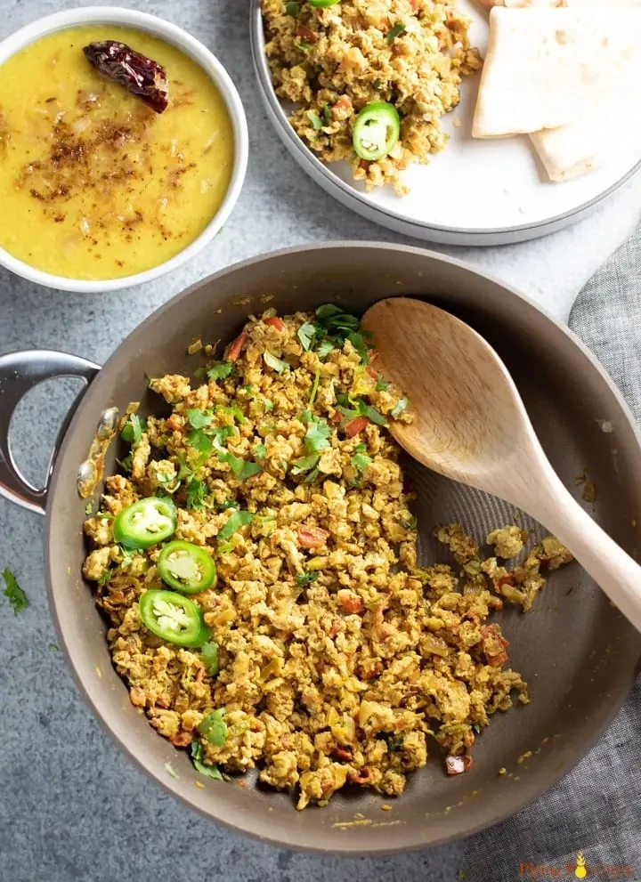 overhead shot of cooking pot with curry in it and a wooden spoon mixing it