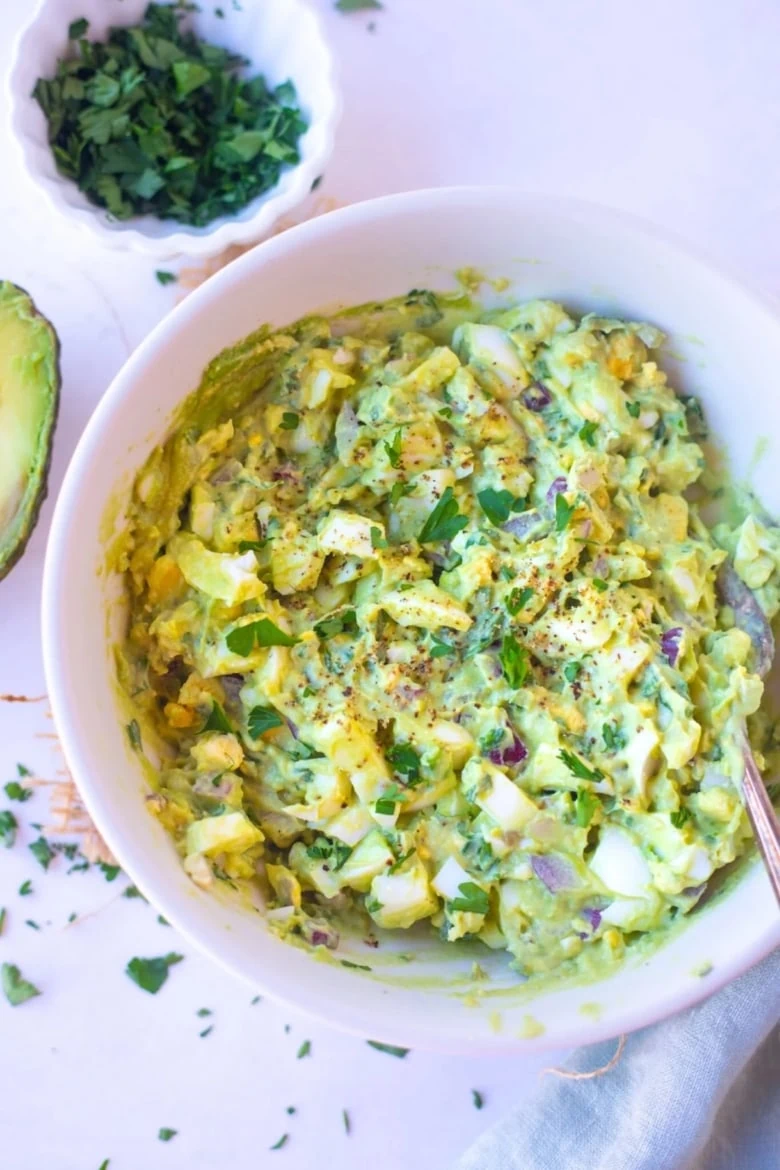 overhead shot of white bowl filled with avocado egg salad