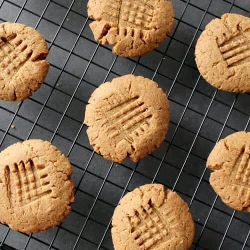 overhead shot of finished gluten-free peanut butter cookies on black wire cooling rack