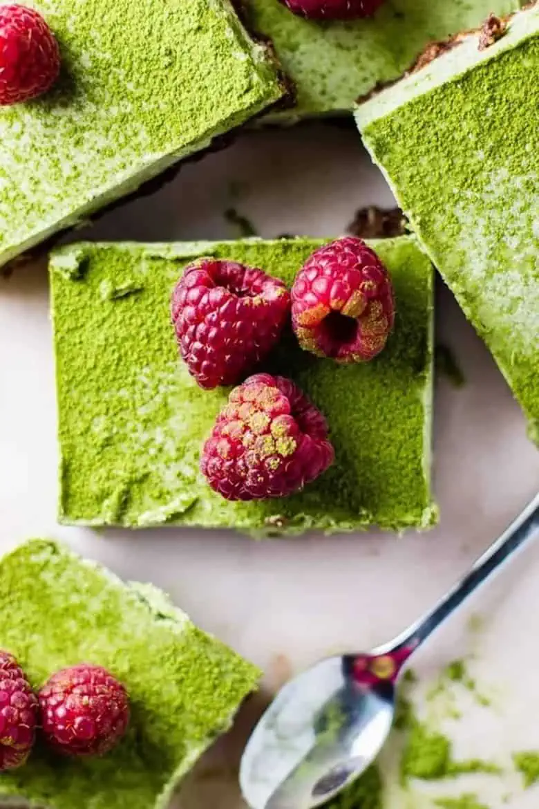 overhead shot of green moringa chocolate bars with raspberries on top