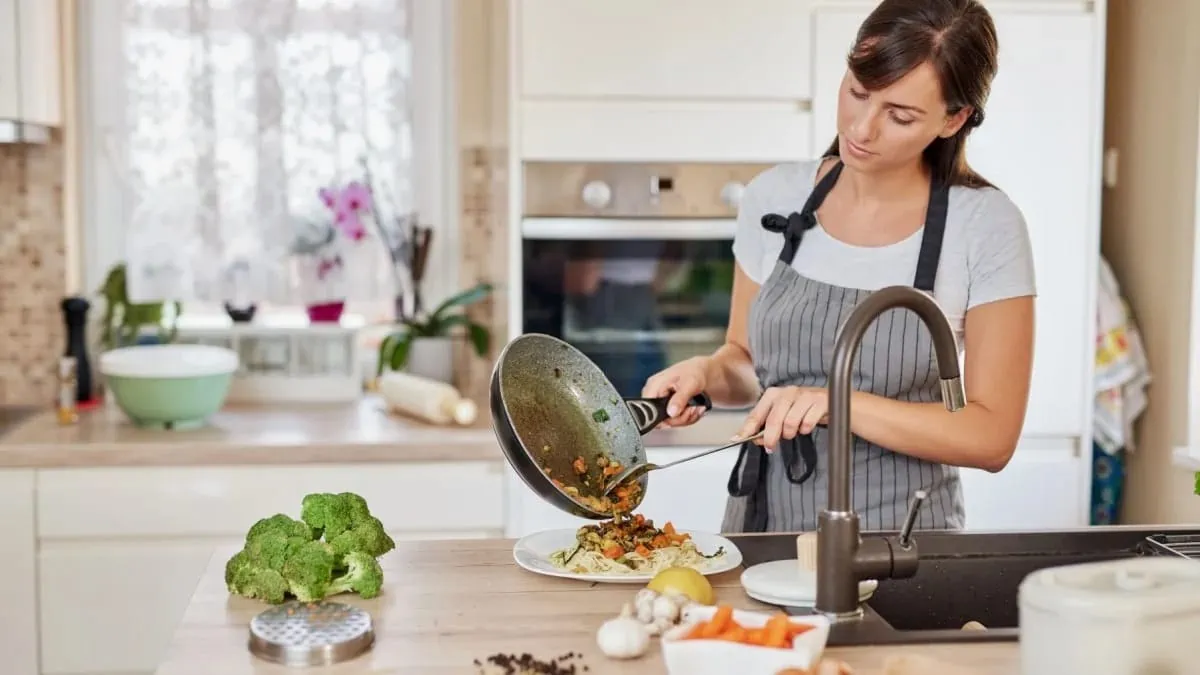 woman cooking frozen vegetables in a skillet