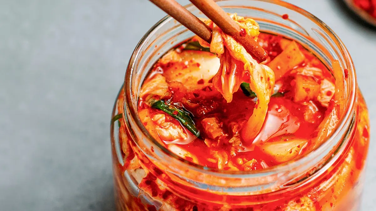 Kimchi, a Korean dish made from fermented vegetables, served conveniently in a jar with chopsticks.
