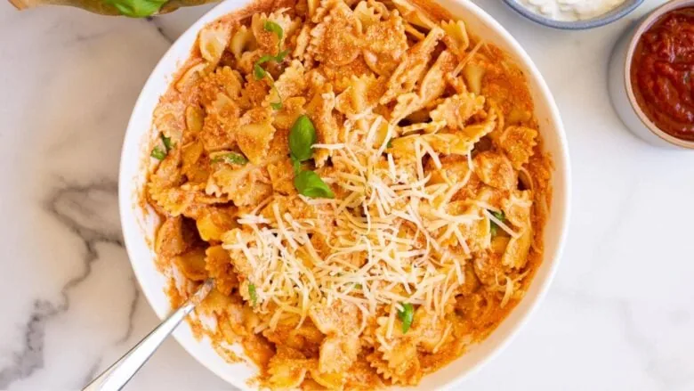 A bowl of pasta with sauce and cheese.