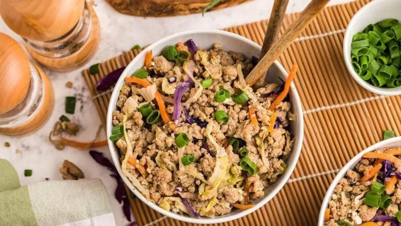 Two bowls of asian stir fry with meat and vegetables.