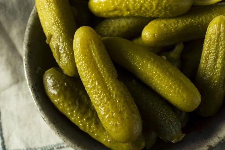 Pickles in a bowl on a table.