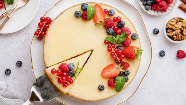 A cheesecake with berries and nuts on a plate.