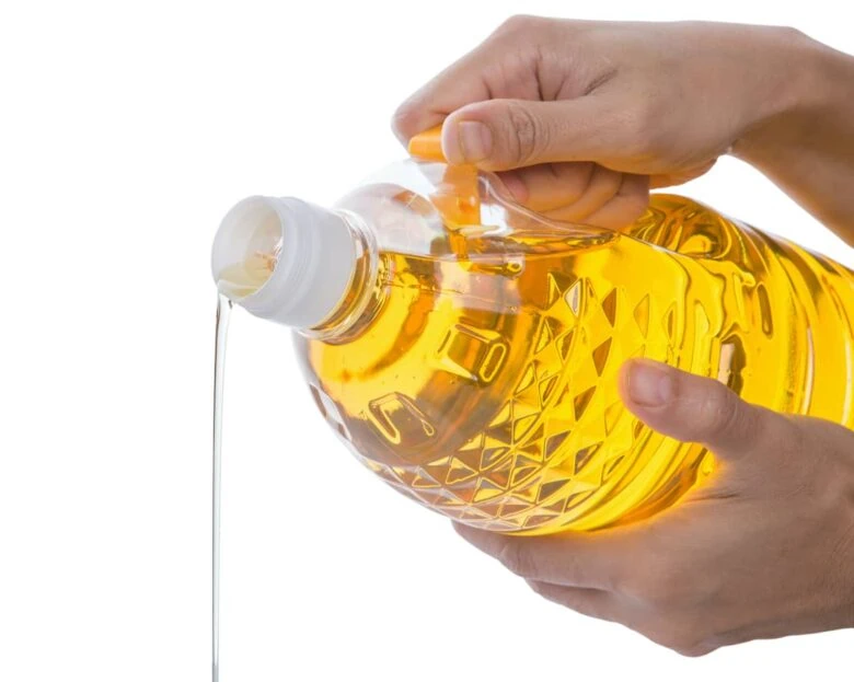 A person pouring unhealthy oil out of a jug.