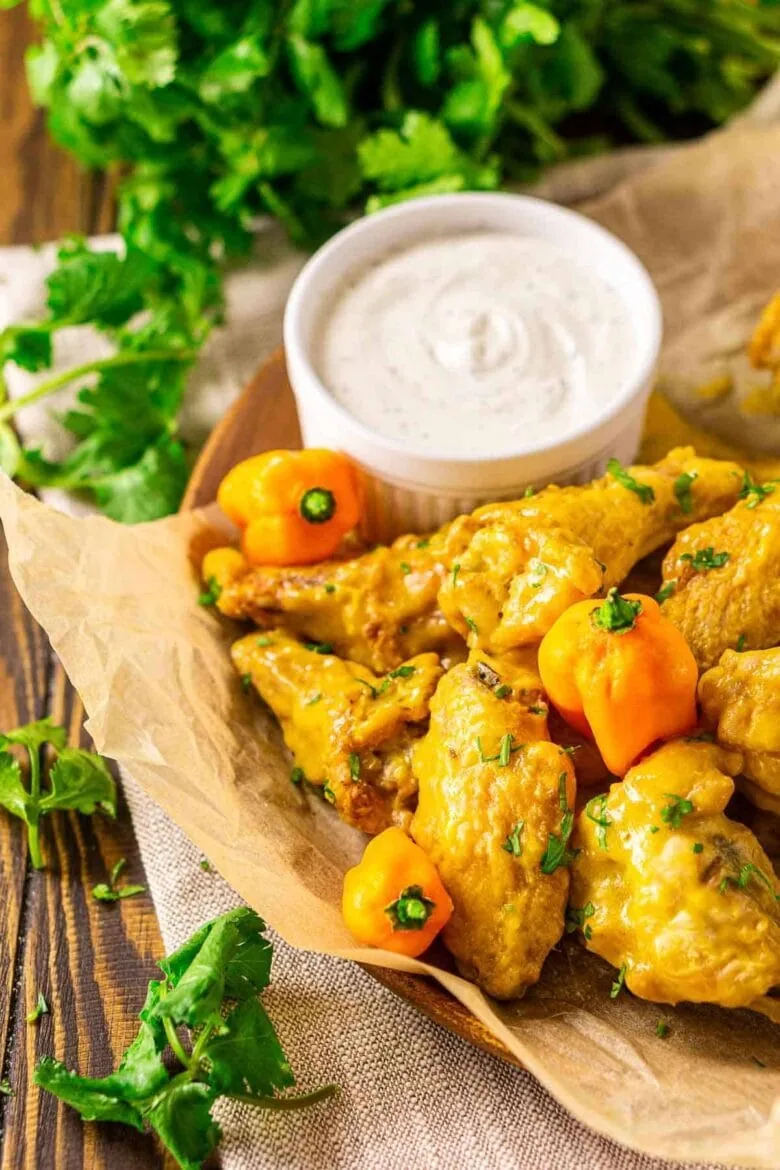 Chicken wings with spicy dipping sauce on a rustic wooden table.