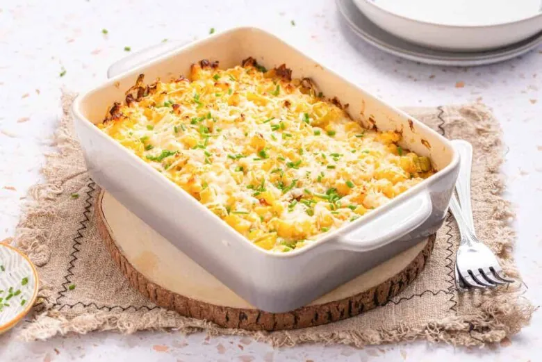 Cheesy macaroni and cheese casserole on a wooden table.