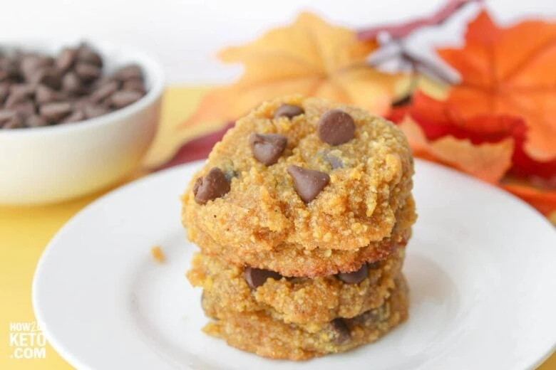 A stack of pumpkin chocolate chip cookies on a plate.