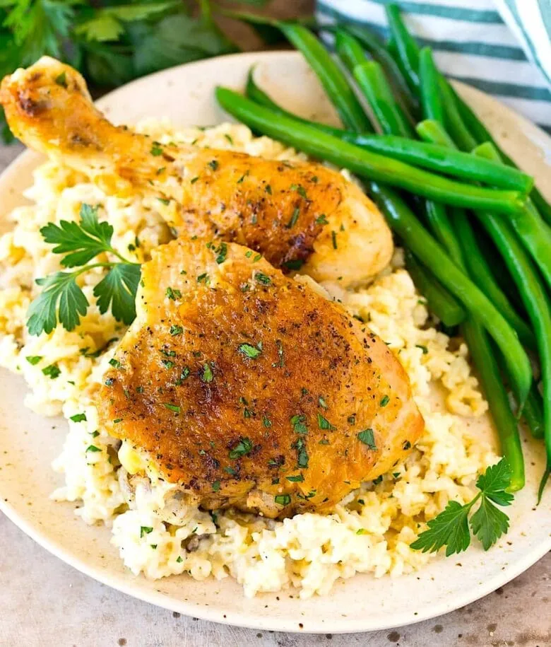 Chicken with rice and green beans on a plate.