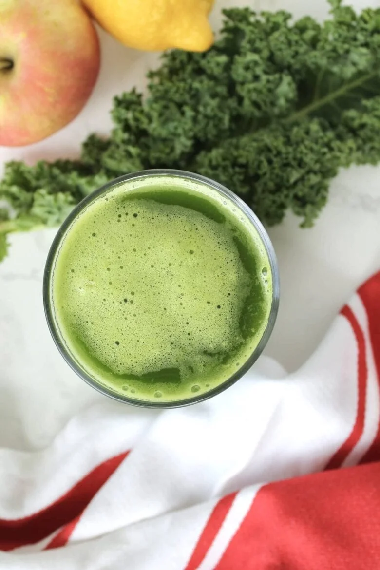 A glass of first watch kale tonic green smoothie with apples and kale.