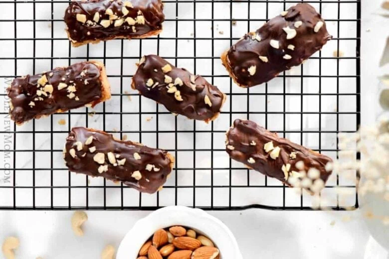 Chocolate peanut butter bars on a cooling rack with almonds.