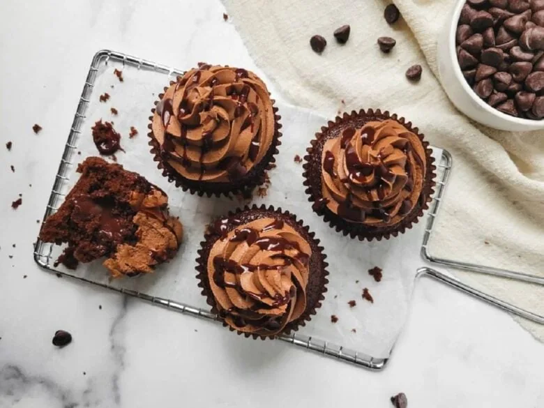 Chocolate cupcakes on a tray with chocolate chips.