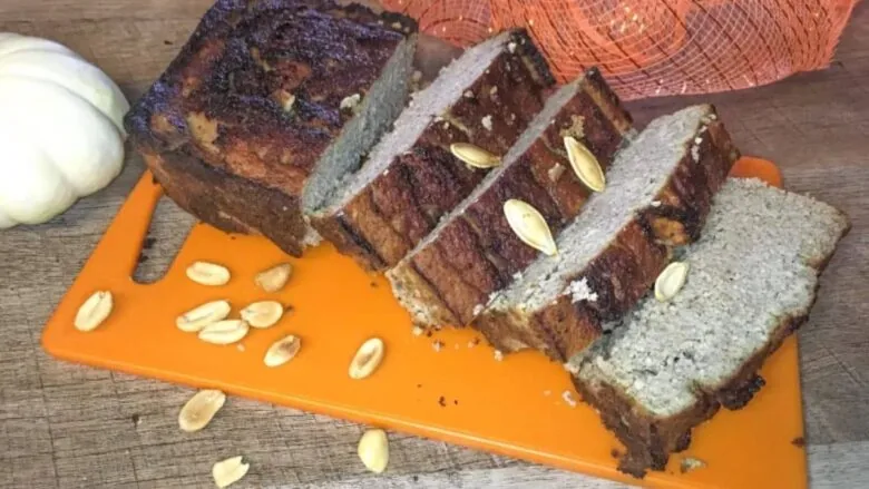 A slice of pumpkin bread on an orange cutting board.