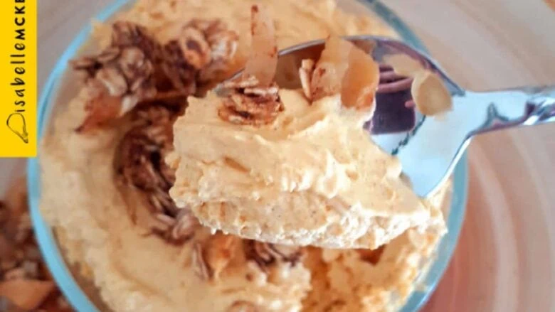 A spoon is holding a bowl of peanut butter ice cream.