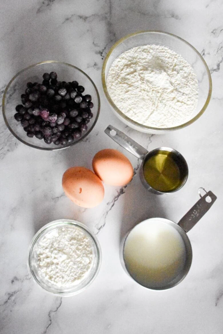 A deliciously simple recipe for blueberry pancakes featuring a mouthwatering blend of fresh blueberries and fluffy batter, all beautifully displayed on a sleek marble table.