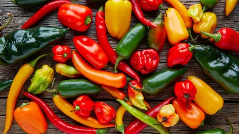Different types of peppers laying on a table.