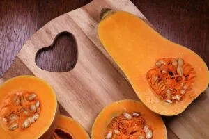 Sliced butternut squashes on a wooden cutting board with a heart-shaped cutout, offering inspiration for what to serve with butternut squash.